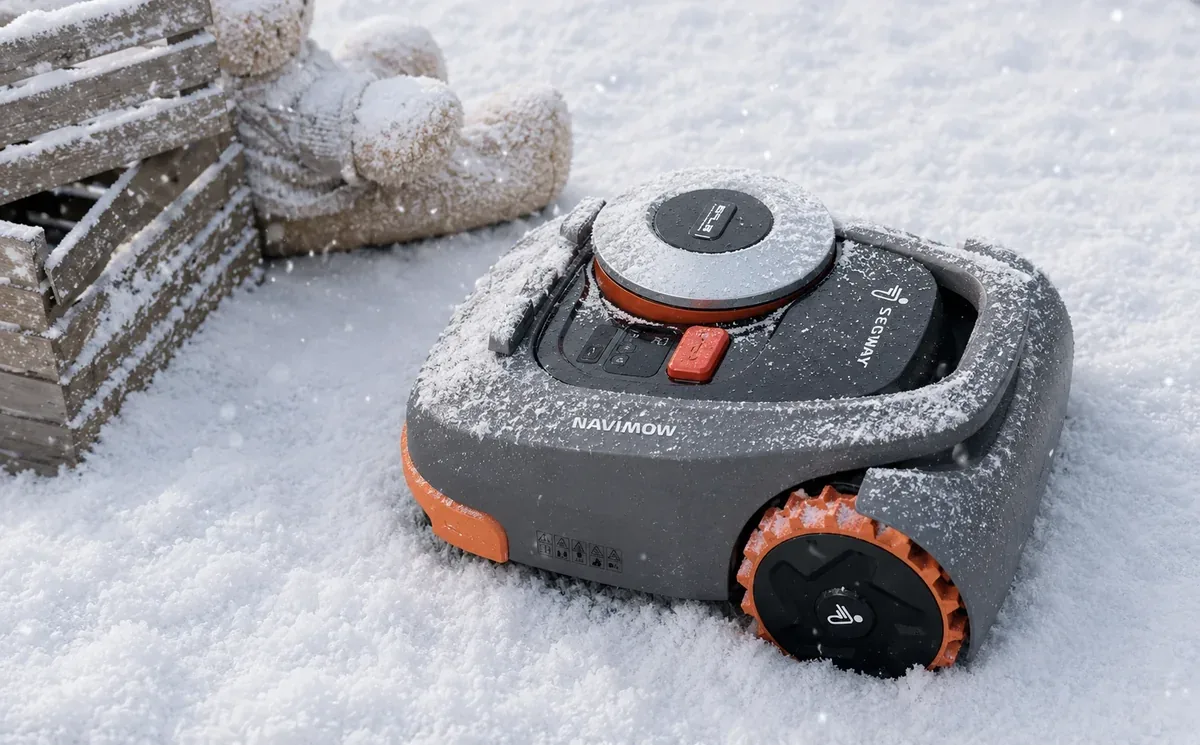 Segway Navimow AWD robotfűnyíró havas kertben, fa tövében — téli felkészítés és tárolás előtt
