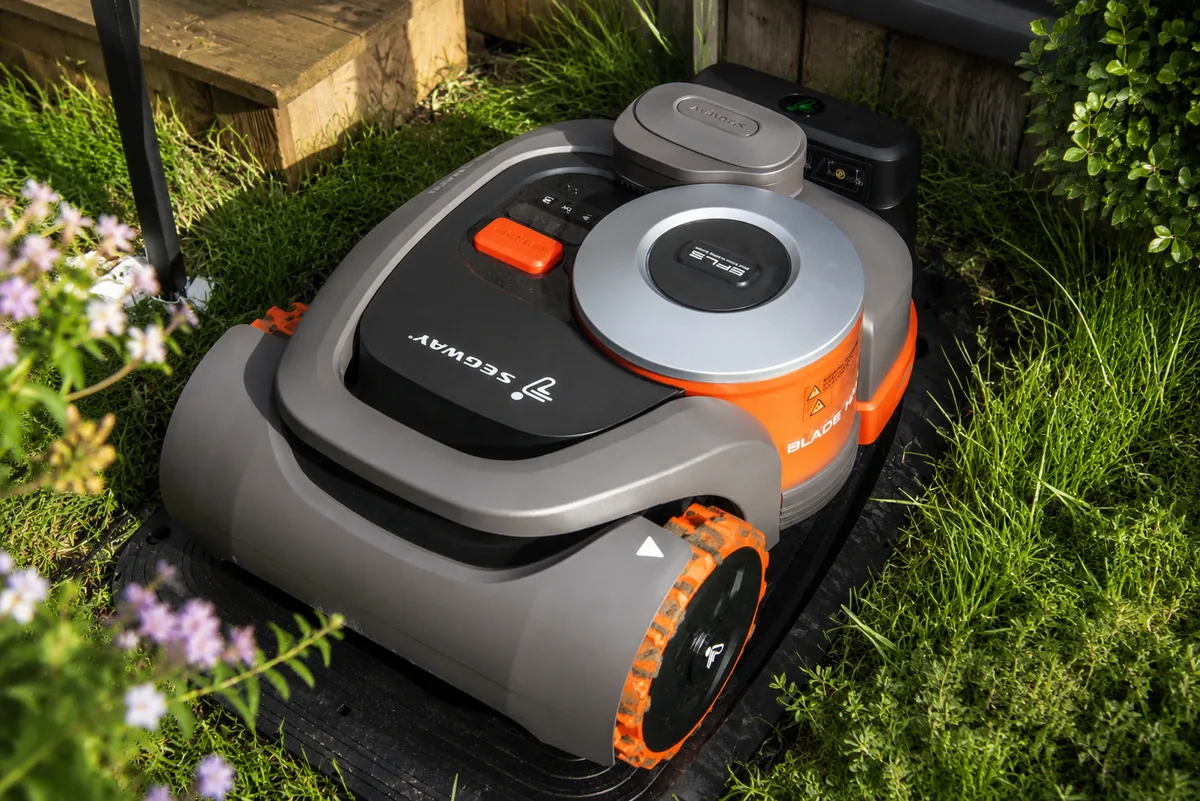 Segway Navimow robotfűnyíró dokkolóállomásban — töltőállomás közelkép kertben